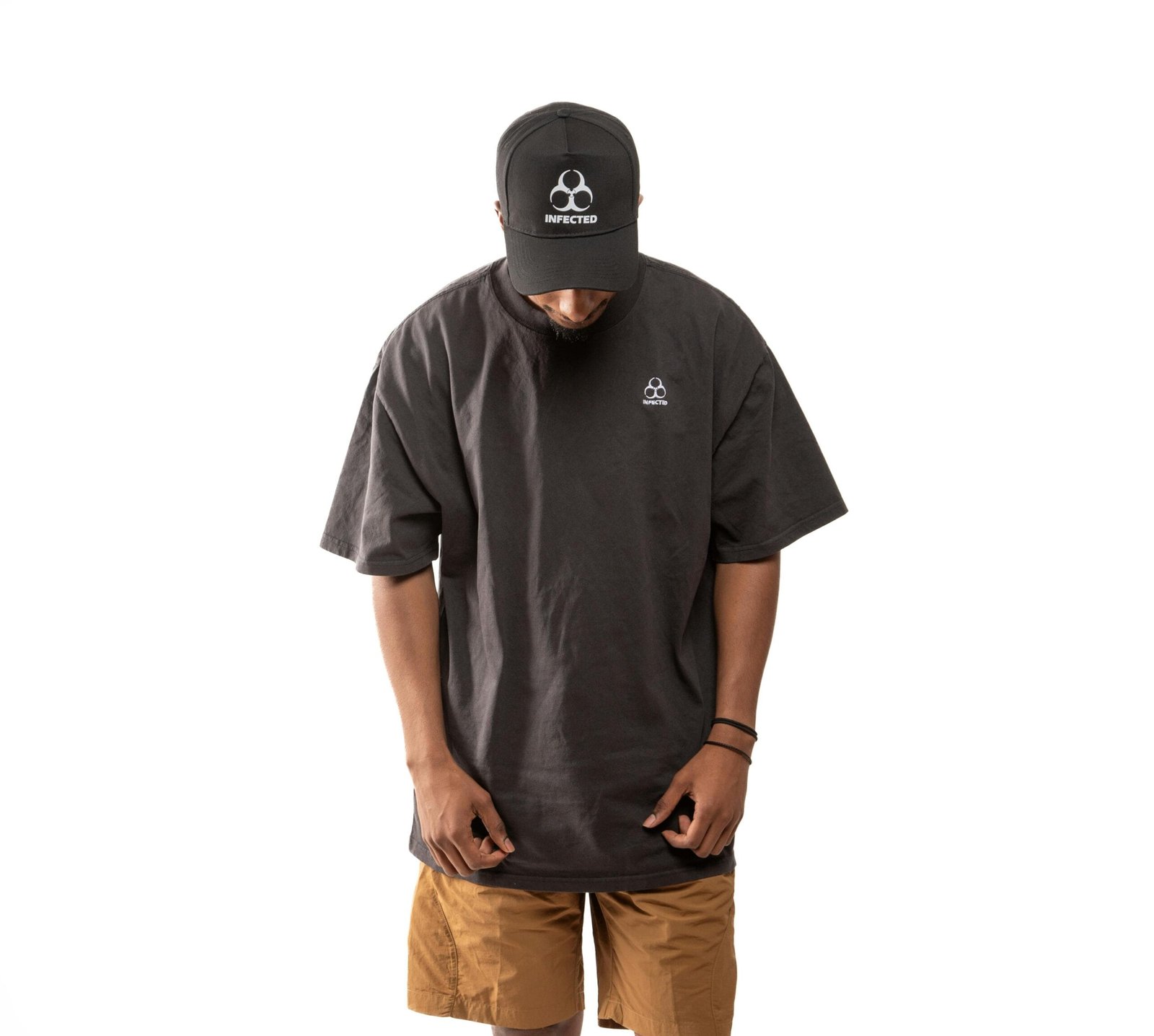 Model wearing oversized black t-shirt and cap on white background.